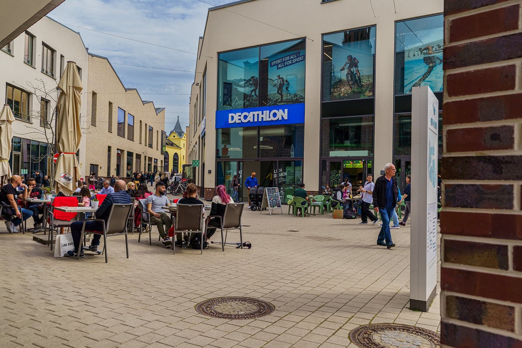 Belebte Fußgängerzone im Rée Carré Stadtquartier mit Außengastronomie und Decathlon-Filiale in Offenburg